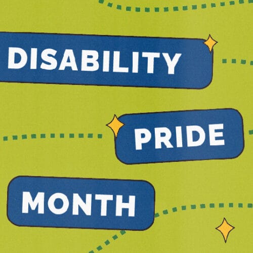 A baby photo of Mark, in a bathroom, posing with his arm on his hip and his other arm on his shoulder with his legs crossed and inverted. He has short black hair and is wearing black shorts, a navy and pink shirt, and black shoes.